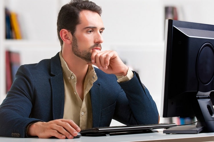 Man thinking while looking at a computer screen