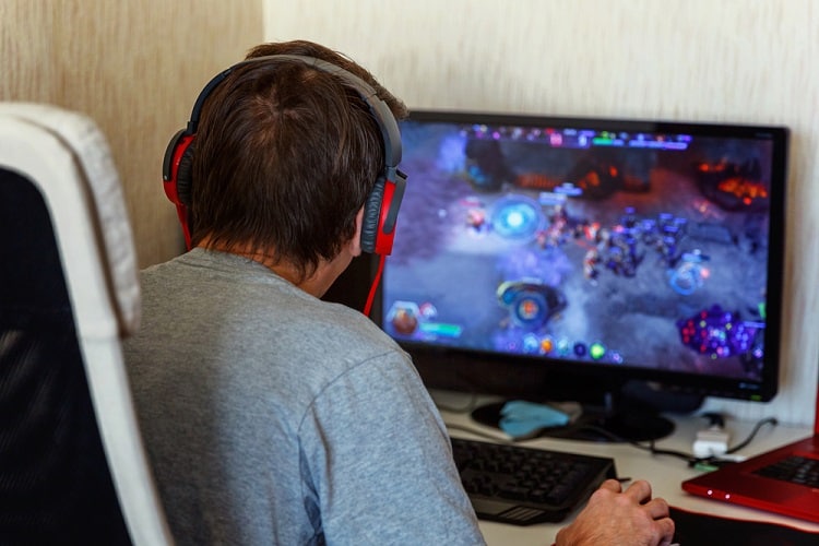 Gamer in headphones using computer