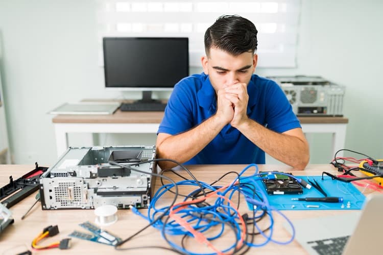 Stressed young man looking at the tangled cables